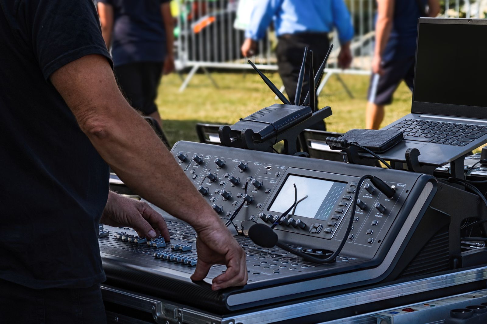 Audio engineer operating a professional mixing console